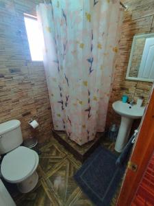 y baño con aseo y lavamanos. en Hostal Perita, en San Pedro de Atacama
