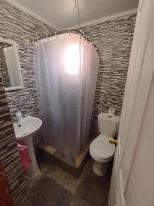 a bathroom with a white toilet and a sink at Hostal Perita in San Pedro de Atacama