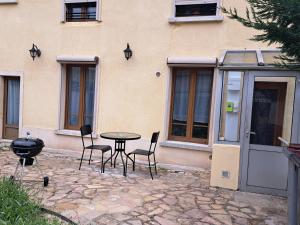 a patio with a table and chairs in front of a building at L'EDEN in Étampes