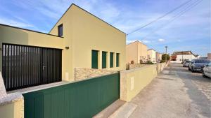 a house with a green gate on a street at Clara's Home in Matosinhos