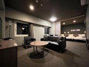 松茂町的住宿－Hotel Route Inn Tokushima Airport -Matsushige Smartinter-，客厅配有沙发和桌子