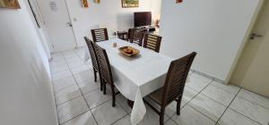 ein Esszimmer mit einem weißen Tisch und Stühlen in der Unterkunft Novo, Iluminado 3 Quartos Piscina Garagem in Ubatuba