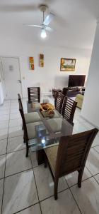 ein Esszimmer mit Glastisch und Stühlen in der Unterkunft Novo, Iluminado 3 Quartos Piscina Garagem in Ubatuba