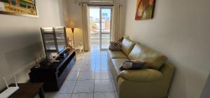 ein Wohnzimmer mit Sofa und Tisch in der Unterkunft Novo, Iluminado 3 Quartos Piscina Garagem in Ubatuba