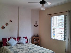 a bedroom with a bed with pillows and a window at Acolhedor com suíte e wi-fi in Praia Grande +37 photos