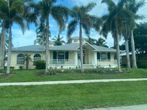 una casa con palmeras delante en Windemere on Marco Island. 4 BR waterfront home en Marco Island