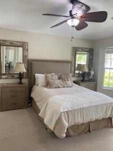 a bedroom with a bed and a ceiling fan at Windemere on Marco Island. 4 BR waterfront home in Marco Island