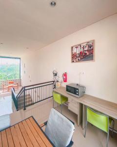 a room with a desk with a microwave and chairs at Olivia SOHO Guest House in Legian