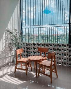 two chairs and a table in front of a window at Olivia SOHO Guest House in Legian