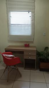 a desk and a chair in a room with a window at Suíte 77 privativa , há 11km da vila germânica in Blumenau