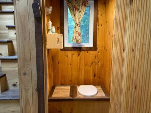 a toilet in a wooden bathroom with a window at Gollé Goulu in Saint Come