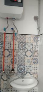 La salle de bains est pourvue d'un lavabo et d'un mur recouvert de carrelage. dans l'établissement Melbyls Hills Resort, à Tomohon