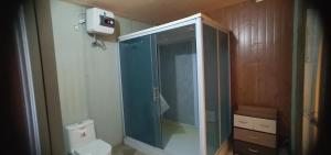 a bathroom with a glass shower and a toilet at Melbyls Hills Resort in Tomohon