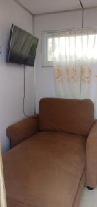 a couch in a small room with a window at Melbyls Hills Resort in Tomohon