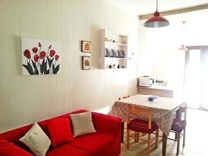 salon z czerwoną kanapą i stołem w obiekcie Holiday home Diaz Buggerru w mieście Buggerru