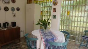 een eettafel met een vaas met bloemen erop bij Holiday House Altea in Banjole