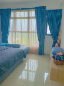 a bedroom with blue curtains and a large window at Atlantis Residence Melaka ForMuslims Homestay in Melaka