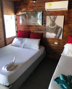 a bedroom with two beds and a picture on the wall at baru express in Cartagena de Indias