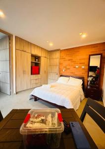 ein Schlafzimmer mit einem Bett und einem Tisch darin in der Unterkunft Studio Suite Campestre con Jacuzzi in Buga