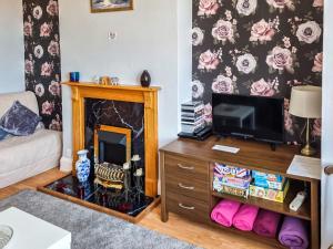 a living room with a tv and a fireplace at Hillrise in Herne Bay
