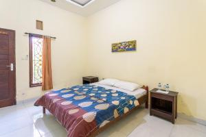 um quarto com uma cama, uma mesa e uma janela em Jero Harum Homestay em Krambitan