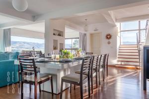 ein Esszimmer mit einem großen Tisch und Stühlen in der Unterkunft Mansão Sky View Vista Panorâmica Luxo na Serra in Rancho Queimado