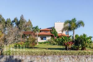 ein Haus mit Palmen davor in der Unterkunft Mansão Sky View Vista Panorâmica Luxo na Serra in Rancho Queimado