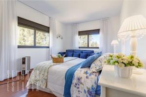 ein Schlafzimmer mit einem Bett und einer blauen Couch in der Unterkunft Mansão Sky View Vista Panorâmica Luxo na Serra in Rancho Queimado