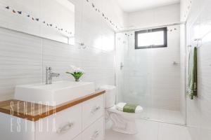 ein weißes Badezimmer mit Waschbecken und Toilette in der Unterkunft Mansão Sky View Vista Panorâmica Luxo na Serra in Rancho Queimado + 31 Fotos
