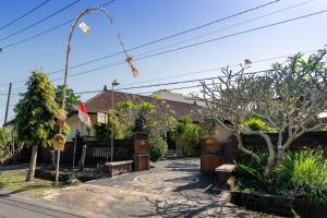 a house with a fence and a yard with trees at Jero Harum Homestay in Krambitan