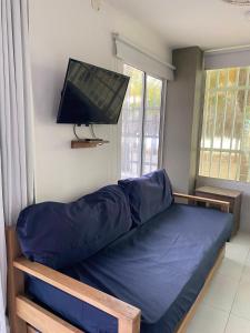 1 dormitorio con 1 cama y TV en la pared en Cabaña Coveñitas 9, en Coveñas