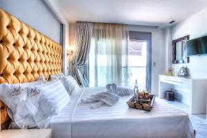a bedroom with a large white bed with a large headboard at Art Boutique in Pefkochori