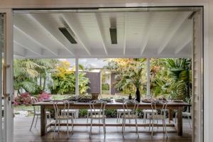 a dining room table with chairs and a large window at Soul of Gerringong Farmhouse in Gerringong +22 photos