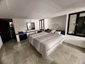 a bedroom with a large bed and a mirror at Secretos del Sol Acapulco villas a 5 minutosdel mar in Acapulco