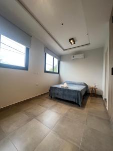a large room with a bed and two windows at MONOAMBIENTE PARA 2 PERSONAS, EXCELENTE UBICACIONn in Santiago del Estero