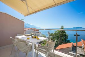 a white table and chairs on a balcony with a view at Apartments by the sea Pisak, Omis - 21568 in Pisak +8 photos