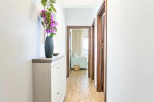 un pasillo con un jarrón de flores en un armario en Apartments by the sea Pisak, Omis - 21568, en Pisak