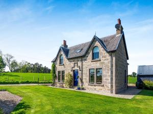 an old stone house with a green lawn at The Laurels in Rafford