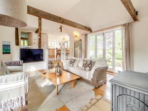 a living room with a couch and a tv at Linen Post Barn in Debenham