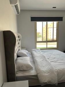 - un lit blanc dans une chambre avec fenêtre dans l'établissement اطلالة الريان شقة خاصة, à Djeddah