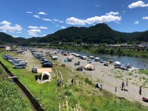 a group of cars parked on a beach next to a river at 吉野長屋 in Yoshino