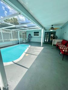 une terrasse avec une piscine, des chaises et une maison dans l'établissement A Cozy Space Coast Retreat, à Titusville