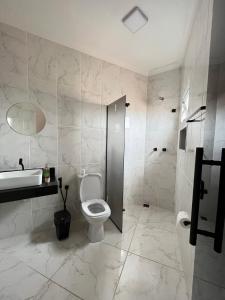 biała łazienka z toaletą i umywalką w obiekcie Casa Lua w mieście Brumadinho