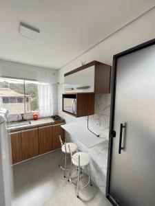 a kitchen with a table and chairs and a counter at Casa Lua in Brumadinho