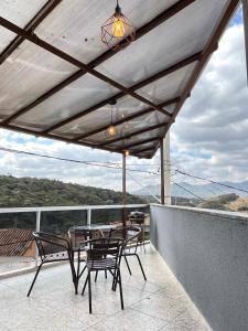 eine Terrasse mit einem Tisch und Stühlen auf dem Balkon in der Unterkunft Casa Lua in Brumadinho