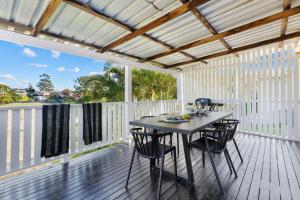 un patio con mesa y sillas en una terraza en The Oyster Shack en Nambucca Heads