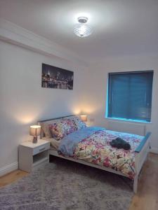 um quarto com uma cama, uma mesa de cabeceira e uma janela em Heronsgate GH015 em Gravesend