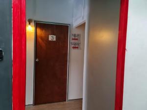 a room with a brown door and a red curtain at Ayden Hostel Airport Transit - KLIA in Sepang