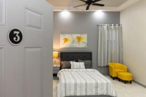 a bedroom with a bed and a yellow chair at 592 Apartments 12 Duncan Street Campbellville, Georgetown in Georgetown