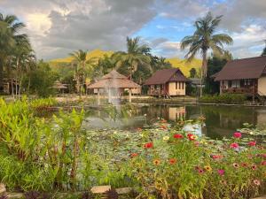 a pond with flowers and a fountain in a resort at Pairadise Hotel in Pai